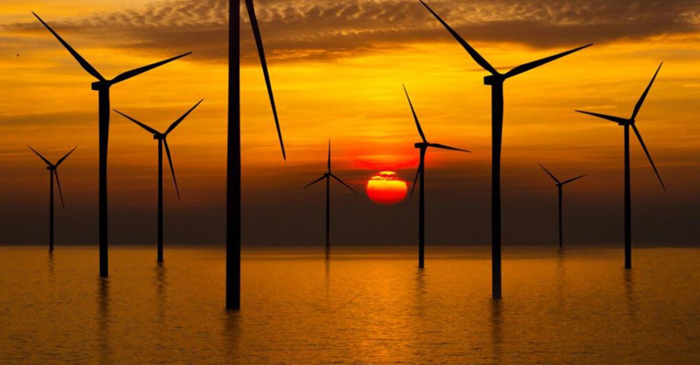 Offshore wind turbine park, seen at sunset.
