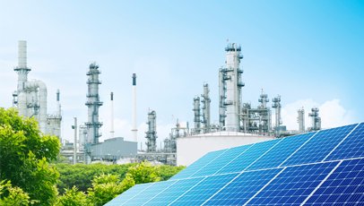 placas solares e refinaria ao fundo